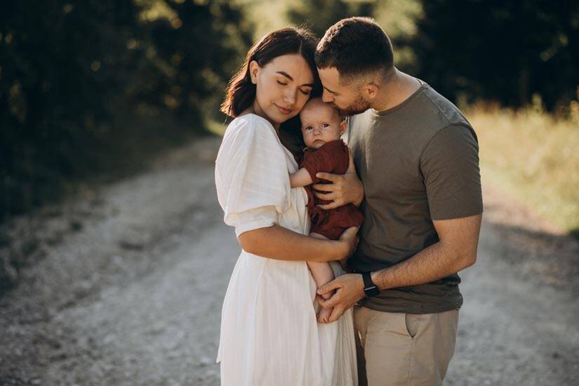 Young Couple With Baby Daughter In Park Glass Printing